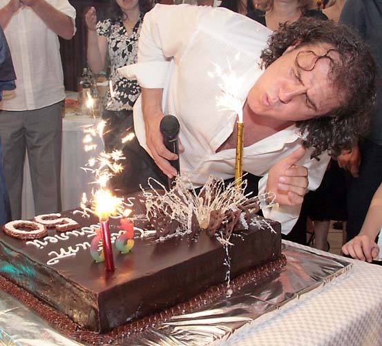 Рожденикът се бори със свещите върху празничната торта