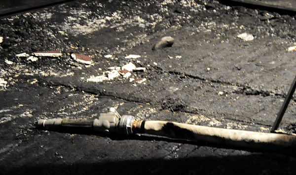 Маркуч от борбата с огъня още се търкаля по обгорялата сцена