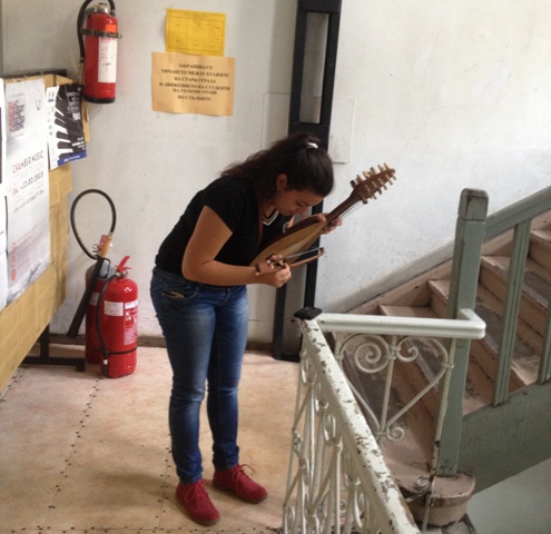 Момиче настройва инструмента си край предупредителни табели на стълбищата в Жълтото училище